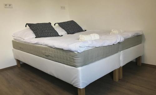 1 cama grande con sábanas blancas y almohadas. en Majorka, en Tiszafüred