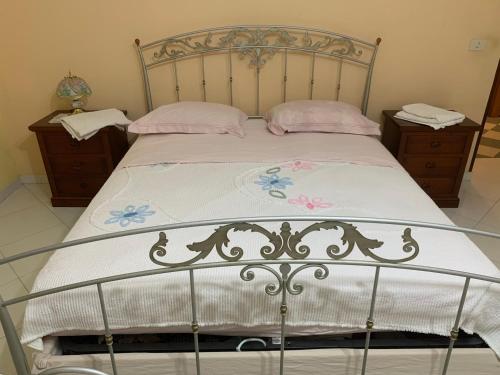 a bed with a metal headboard and two night stands at B&B arpaia in Arpaia