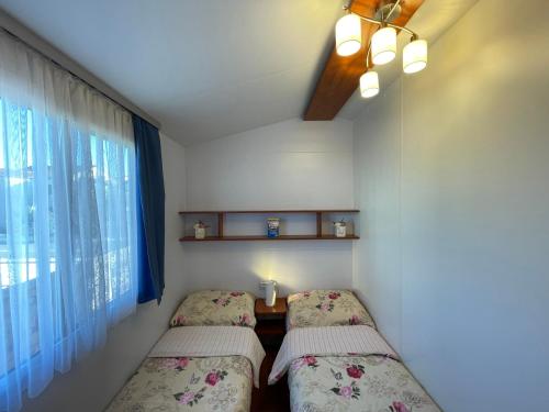圖納的住宿－Mobile Home Daniel，小型客房 - 带2张床和窗户