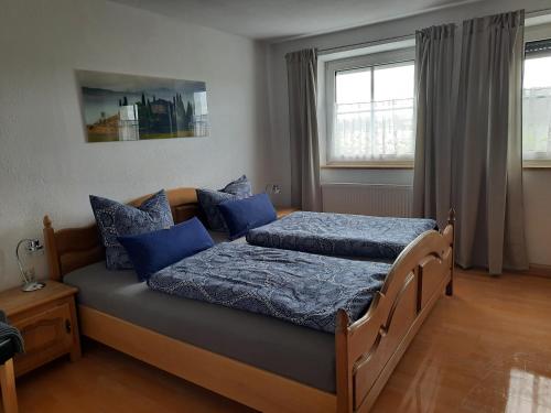 a bedroom with two beds with blue pillows at Binder's Ferienapartments zur Altmühl in Herrieden