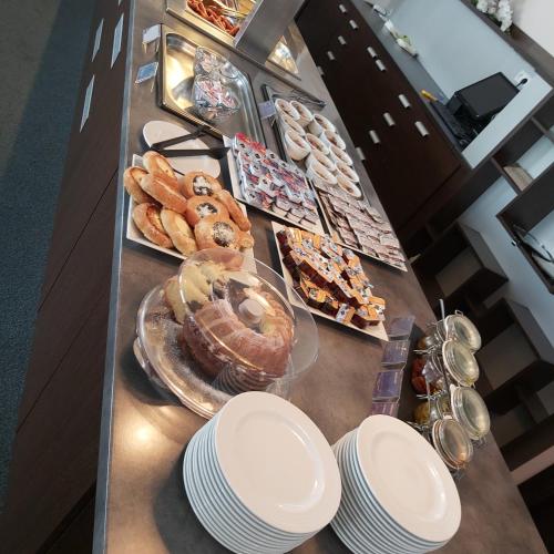 a table with plates of pastries and other food at Apartmany Panorama 10X-90X in Štrbské Pleso