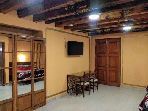 Habitación con mesa y TV en la pared. en Cuartel 1914 - Hotel Boutique, en Zacatecas