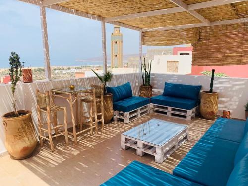d'une terrasse dotée d'un mobilier bleu, d'une table et d'une tour d'horloge. dans l'établissement Well being point, à Agadir