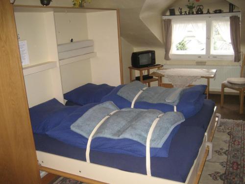 Schlafzimmer mit einem Bett mit blauer Bettwäsche in der Unterkunft Gästehaus Luise in Monschau