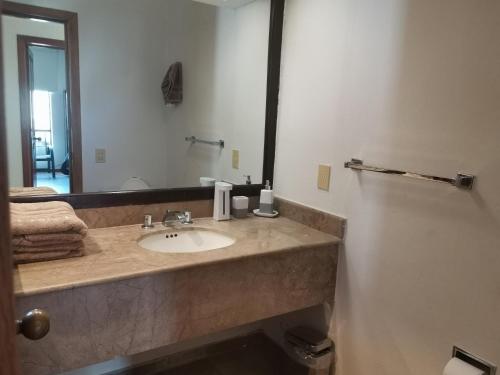 baño con lavabo y espejo grande en Villa Privada ubicada en el campo de Golf del Hotel Vidanta Mayan Palace, en Acapulco