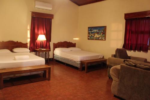 ein Hotelzimmer mit 2 Betten und einem Sofa in der Unterkunft Hotel La Omaja in Mérida
