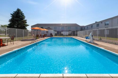 a large blue swimming pool in front of a building at Days Inn by Wyndham Sandusky Cedar Point in Sandusky