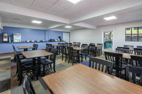 a dining room with wooden tables and chairs at Days Inn by Wyndham Sandusky Cedar Point in Sandusky