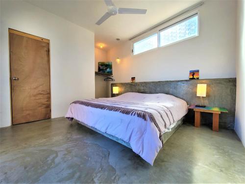 a bedroom with a bed and a table and a window at La Ventana Hostel in La Ventana