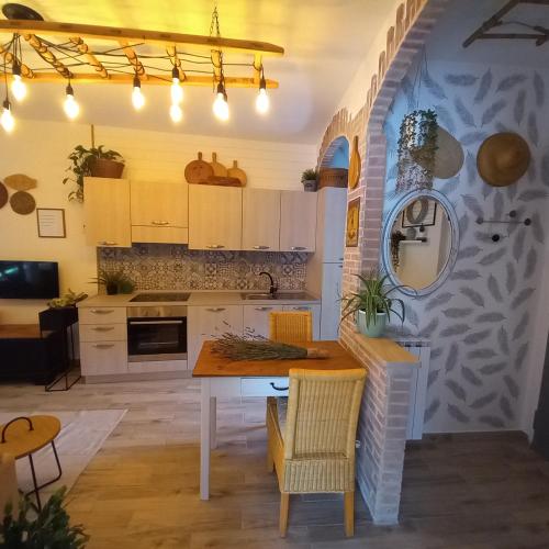 a kitchen with white cabinets and a table and chairs at Casa Fiorita 22 Porto Ceresio in Porto Ceresio