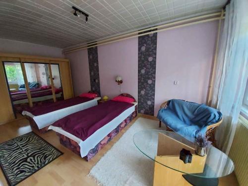 a bedroom with two beds and a table and a couch at Apartment in Balatonalmadi/Balaton 17977 in Balatonalmádi