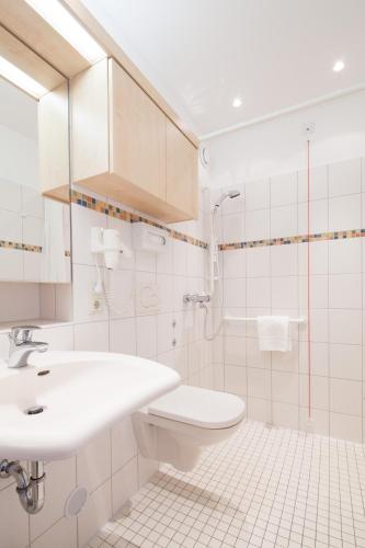 a bathroom with a sink and a toilet and a shower at GDA Hotel Göttingen in Göttingen