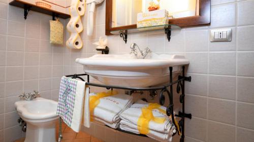 a bathroom with a sink and a toilet and towels at Le Terre Di Giano in Paciano
