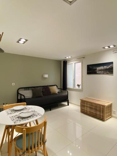 ein Wohnzimmer mit einem Sofa und einem Tisch in der Unterkunft Studio La Tour in Saint-Étienne-de-Tinée