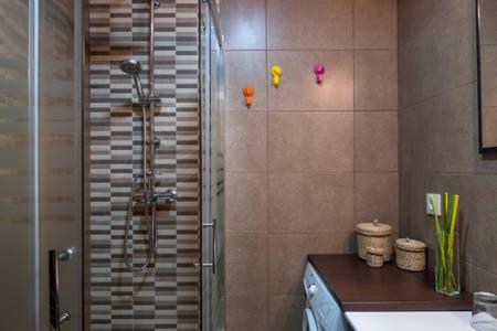 La salle de bains est pourvue d'une douche et d'une porte en verre. dans l'établissement KVARA - Apartamento de diseño, à Vigo