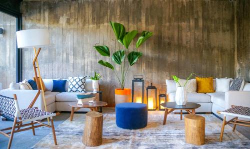 a living room with a couch and chairs and tables at Ximena Hotel Boutique in Sayulita