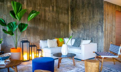 a living room with a white couch and chairs at Ximena Hotel Boutique in Sayulita