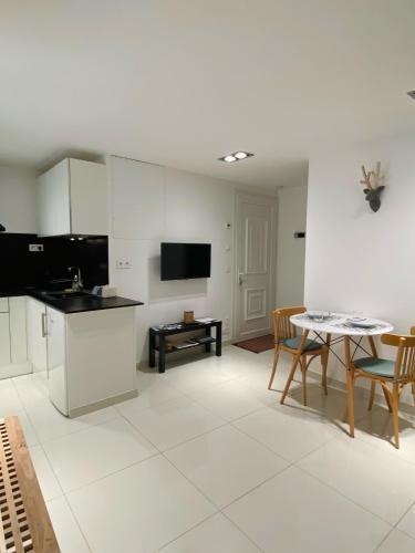 une cuisine et un salon avec une table et des chaises dans l'établissement Studio La Tour, à Saint-Étienne-de-Tinée