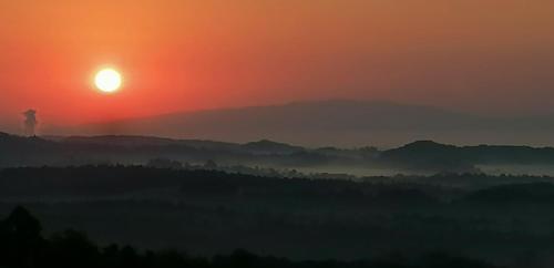 a person standing on top of a hill at sunset at Natural Cottage Glamping Eco-Tiny House in Škocjan