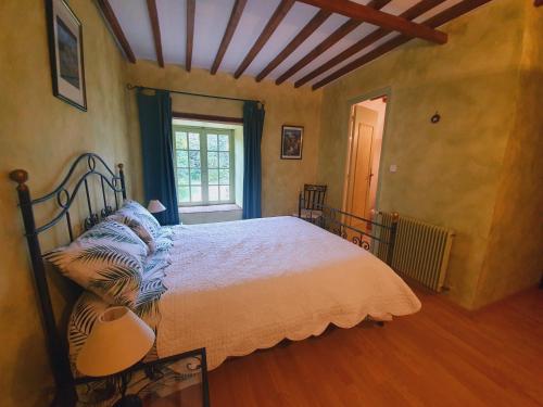 a bedroom with a bed in a room with a window at Ferme équestre & Chambres d'hôtes Gateau Stables proche Guédelon in Saint-Amand-en-Puisaye