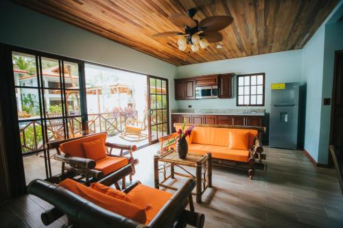 a living room with orange furniture and a ceiling fan at Bungalows Punta Uva in Punta Uva