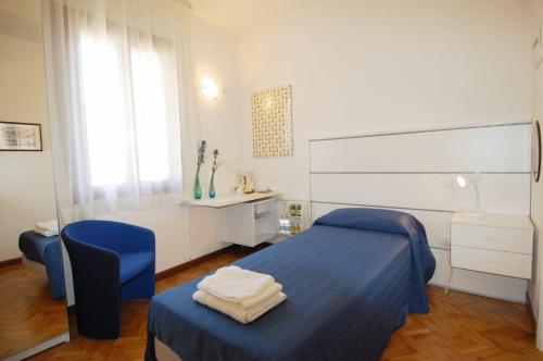 1 dormitorio con cama, silla y escritorio en Santa Margherita Guest House en Venecia