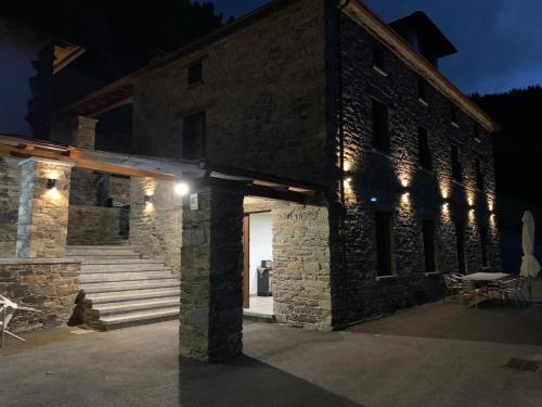 un bâtiment en briques avec des lumières allumées la nuit dans l'établissement Casa Souto Robledo, à Calabreo