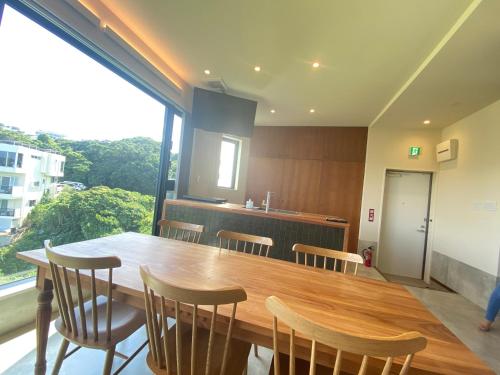 a dining room with a wooden table and chairs at セナはハウスB02 in Yomitan