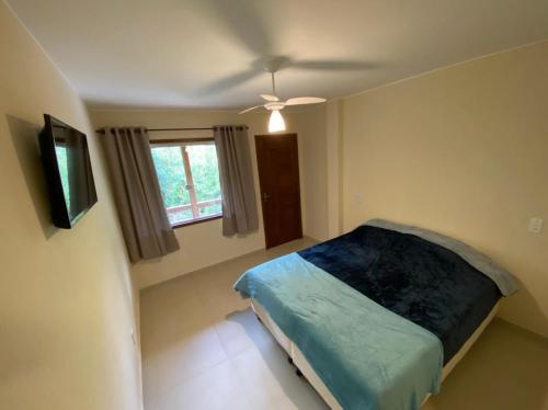 um quarto com uma cama e uma ventoinha de tecto em Espaço Beira Rio em Nova Friburgo