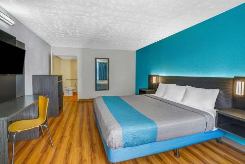 a large bed in a room with a blue wall at Motel 6-Lexington, KY - East I-75 in Lexington