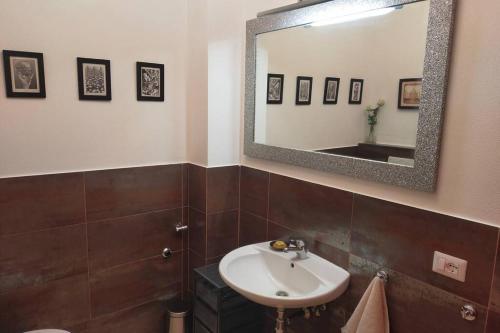 ein Bad mit einem Waschbecken und einem Spiegel in der Unterkunft Poggio ai Grilli Apartment in Certaldo