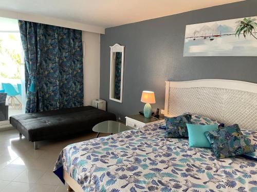 a bedroom with a bed and a couch in it at Résidence de la Vieille Tour in Le Gosier