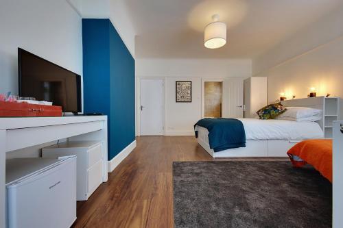 a bedroom with a bed and a blue accent wall at Large En-suite by the Beach in Bournemouth