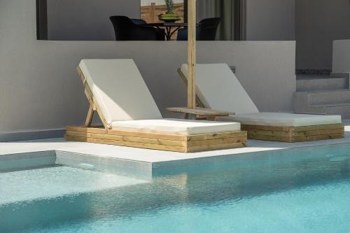 two lounge chairs sitting next to a swimming pool at Casa Nostos in Agia Marina Nea Kydonias