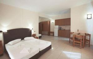a large room with a bed and a kitchen at Theo Beach Hotel Apartments in Rethymno Town