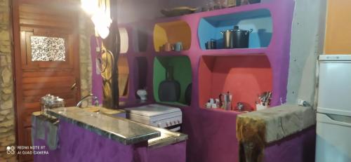 una cucina con lavandino e parete viola di Il Nuraghe ad Arbus