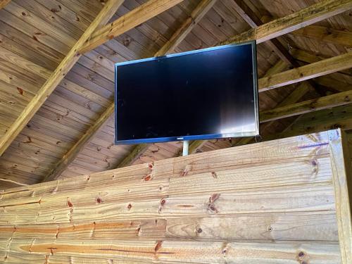 uma televisão de ecrã plano no tecto de um chalé de madeira em Cabana Refúgio canyon Malacara em Praia Grande