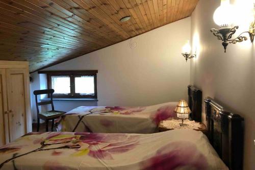 a bedroom with two beds and a lamp on a table at La Maison des Hirondelles Alloggio ad uso turistico - VDA SAINT-PIERRE 0035 in Saint-Pierre