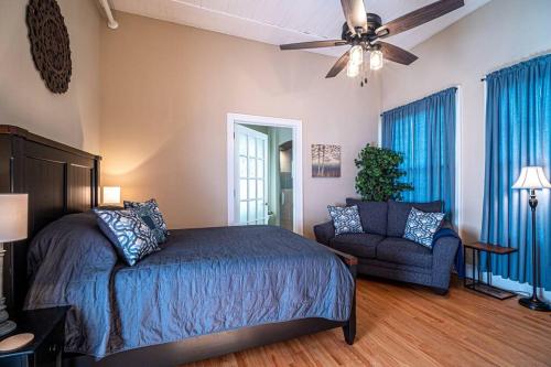 a bedroom with a bed and a couch and a ceiling fan at Historic Tate House Apartment by Marietta Square in Marietta