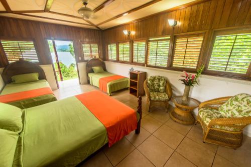 a bedroom with two beds and chairs and windows at Drake Paradise Point in Drake