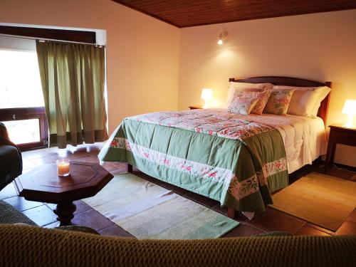 a bedroom with a bed and a living room at Casa do Pontelhão Serra d'Arga in Arga de Cima
