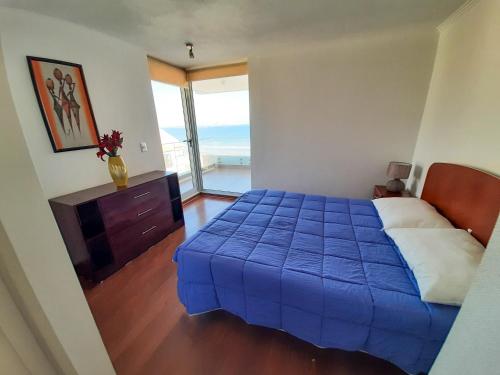 ein Schlafzimmer mit einem blauen Bett und einem Fenster in der Unterkunft Edificio Doña Anita Dpto 906 in La Serena