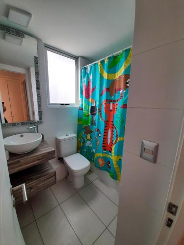 ein Badezimmer mit Toilette, Waschbecken und Duschvorhang in der Unterkunft Edificio Doña Anita Dpto 906 in La Serena