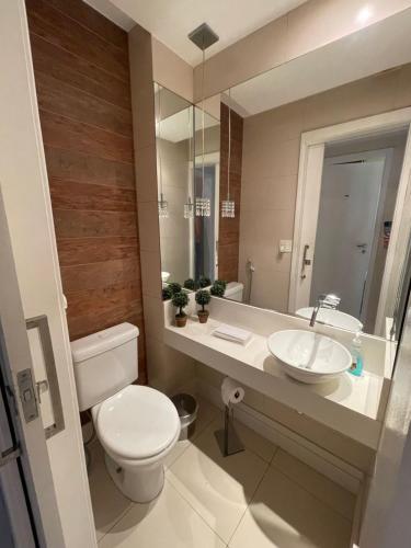 a bathroom with a toilet and a sink at Hotel Petit Village Icaraí in Niterói