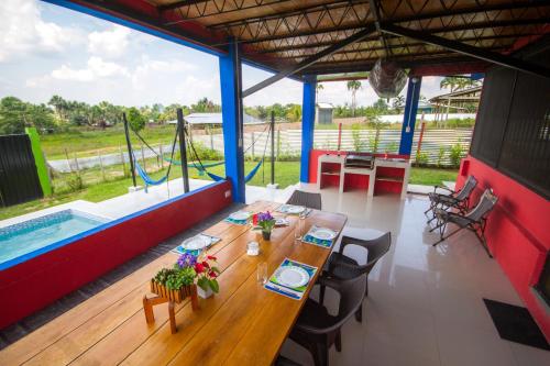 comedor con mesa y piscina en Guacamayo Azul, en Iquitos