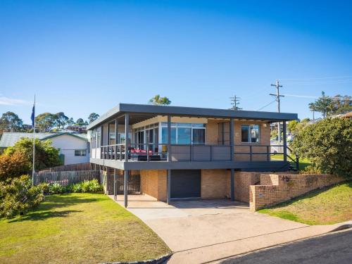 a large house with a balcony on a street at 19 Lakeview Drive Narooma in Narooma