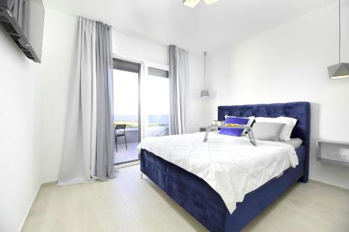 1 dormitorio con cama azul y ventana grande en Villa Juniperus, en Šmrika