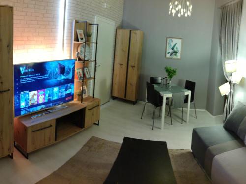 uma sala de estar com uma grande televisão e uma mesa em Inbox Apartments em Bitola
