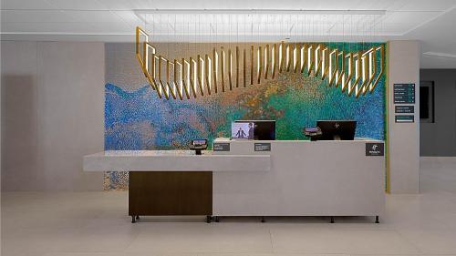 a reception desk with a large painting on the wall at Holiday Inn Chicago Midway Airport S, an IHG hotel in Chicago
