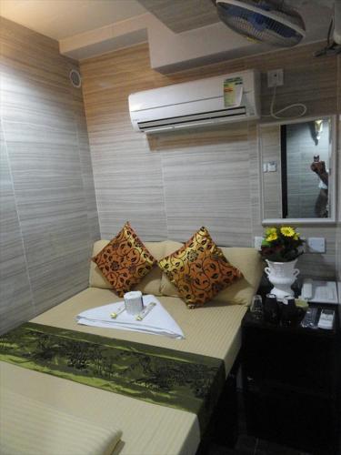 a room with a couch with pillows on it at Day and Night Hostel Block D 10th floor 24 HOUR RECEPTION in Hong Kong